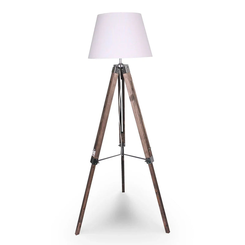 Modern tripod floor lamp with a white lampshade and wooden legs on white background