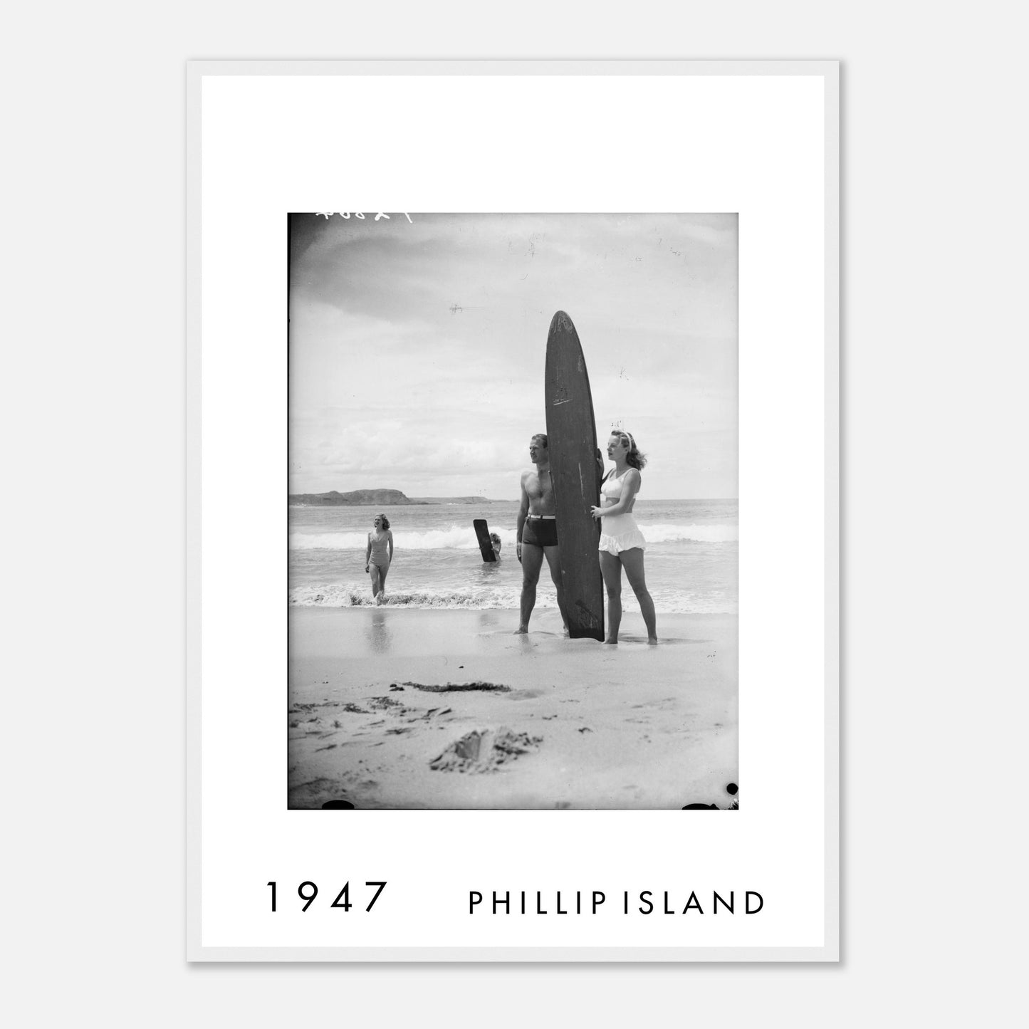Surfboard on the Shore, Phillip Island VIC 1947 framed vintage print featuring beachgoers beside a long surfboard on the shoreline.