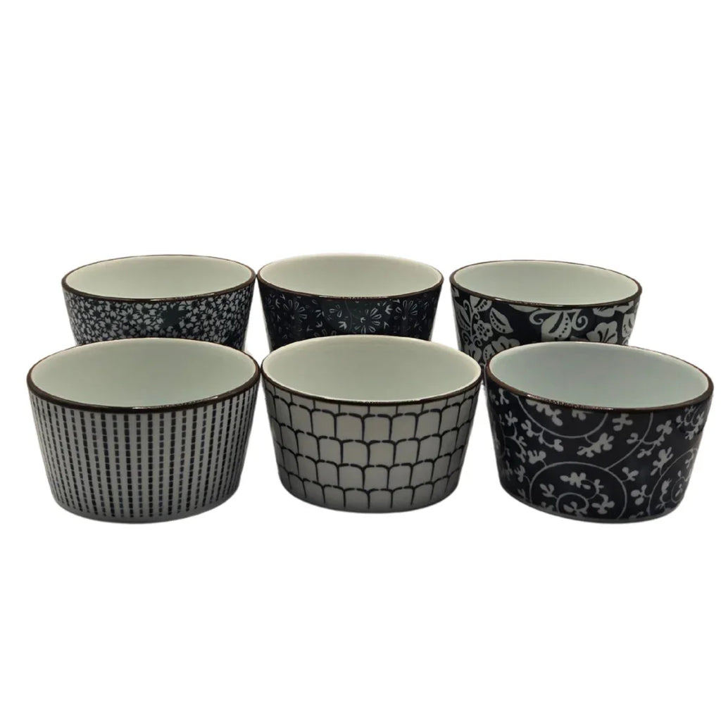 Set of six black and white patterned ceramic ramekins on a white background