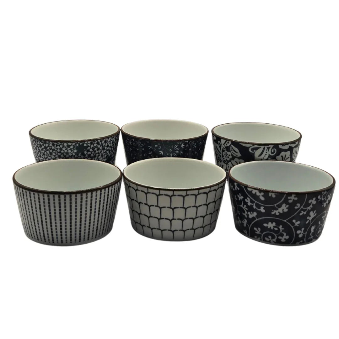 Set of six black and white patterned ceramic ramekins on a white background