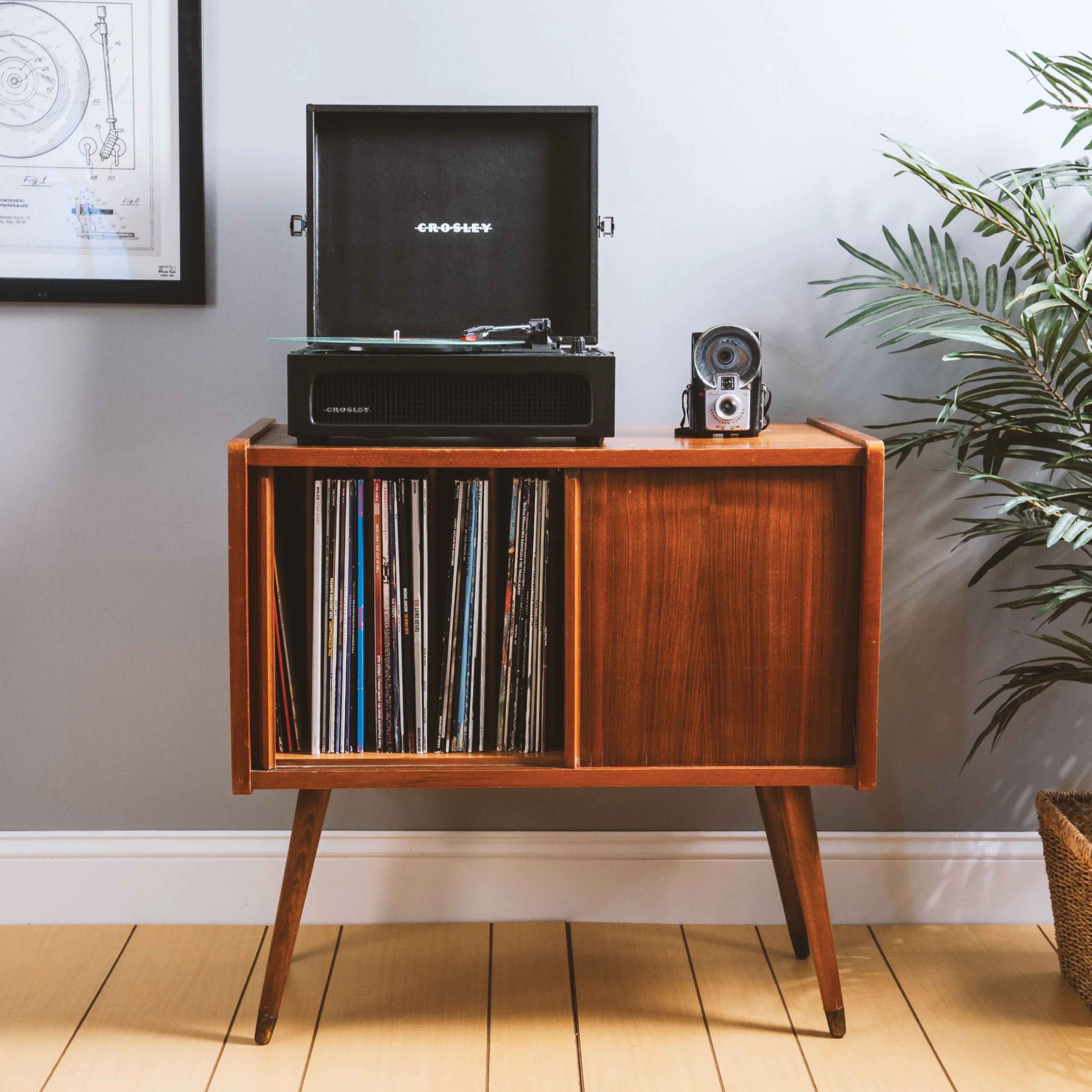 Mid-century modern record player cabinet with vinyl records and retro camera
