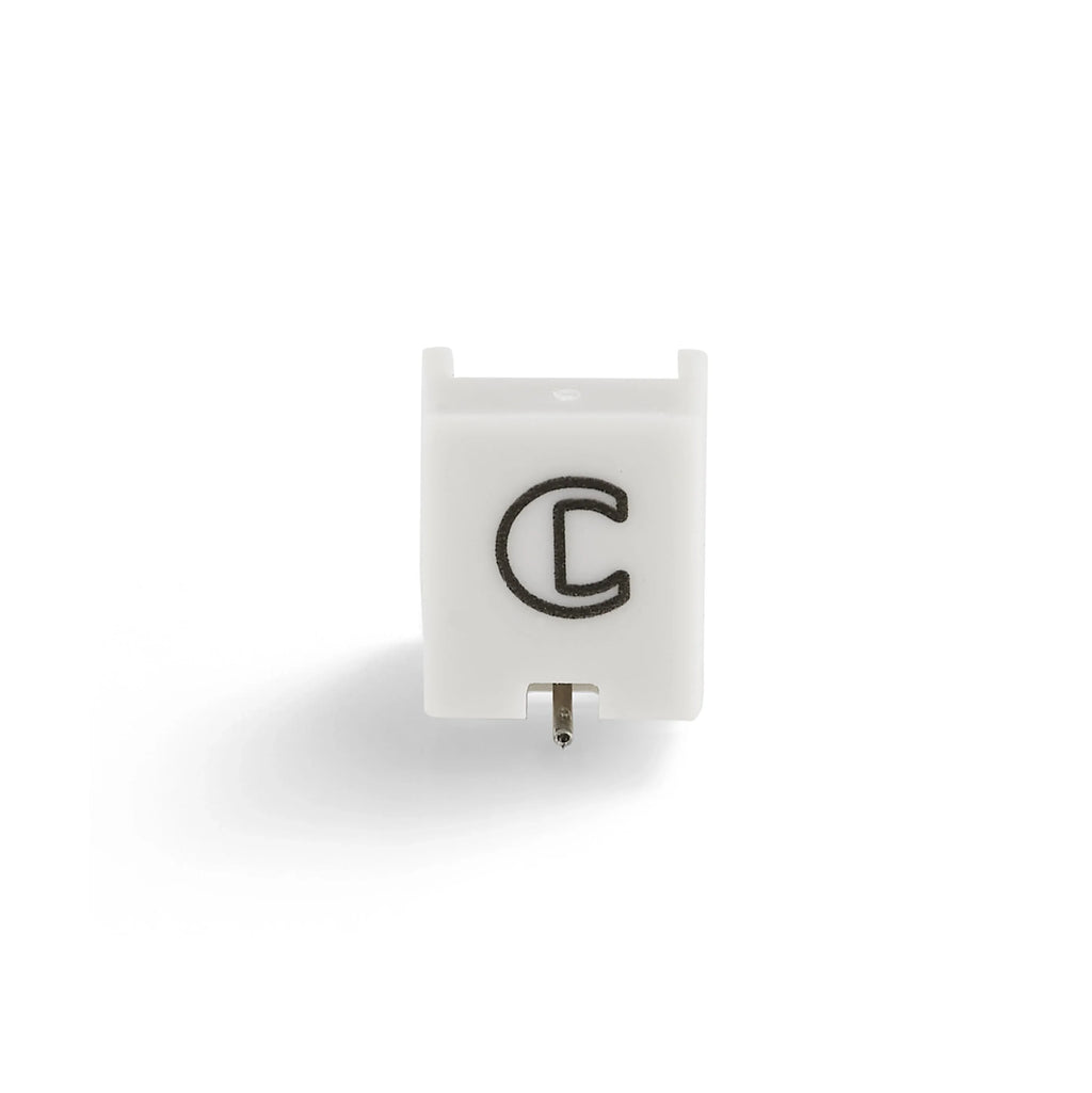 White replacement turntable stylus with black C logo on a white background