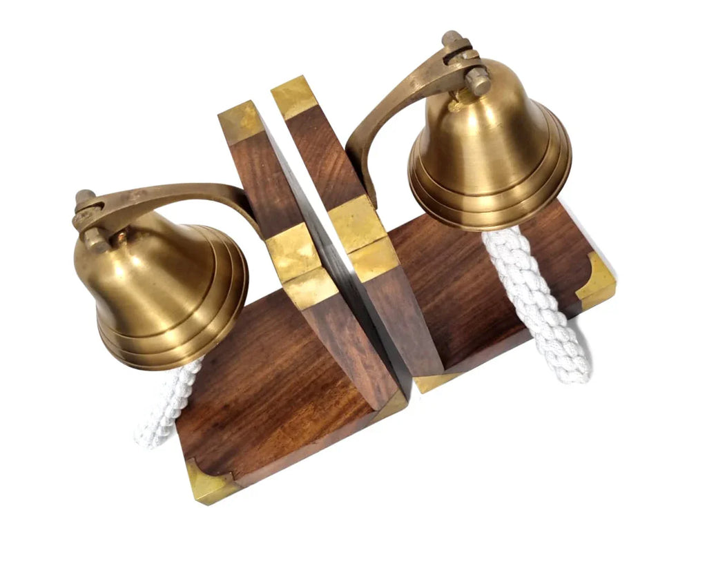 Pair of brass ship bell bookends with wooden bases and white rope accents