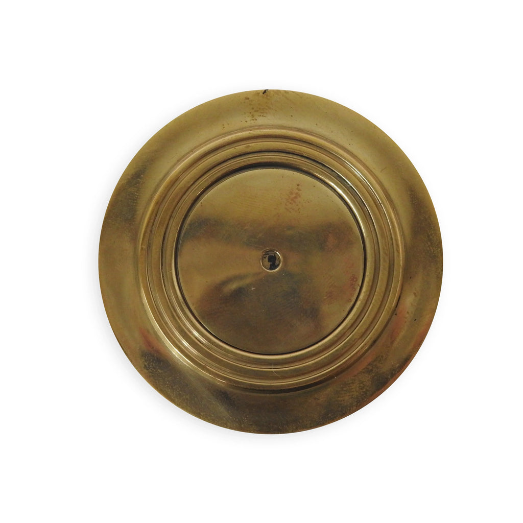 Round brass keyhole cover with concentric circles on white background