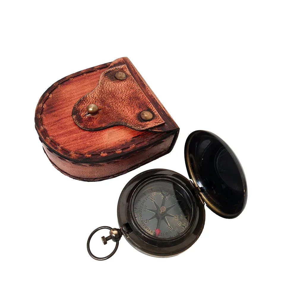 Vintage brass pocket compass with open lid and brown leather case on white background