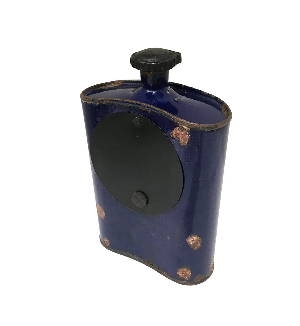 Vintage blue metal flask with black screw cap and rust spots on white background