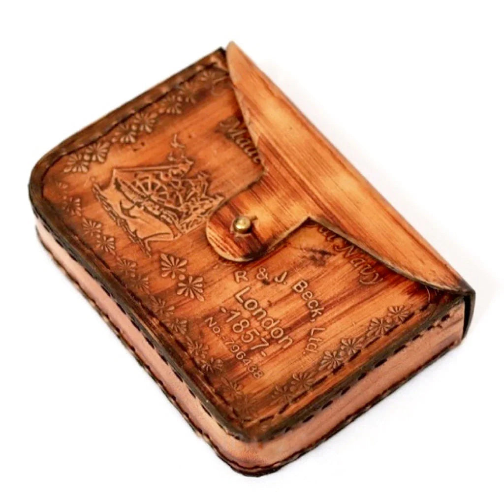 Vintage brown leather case with floral embossing and engraved ship, labeled London 1857.