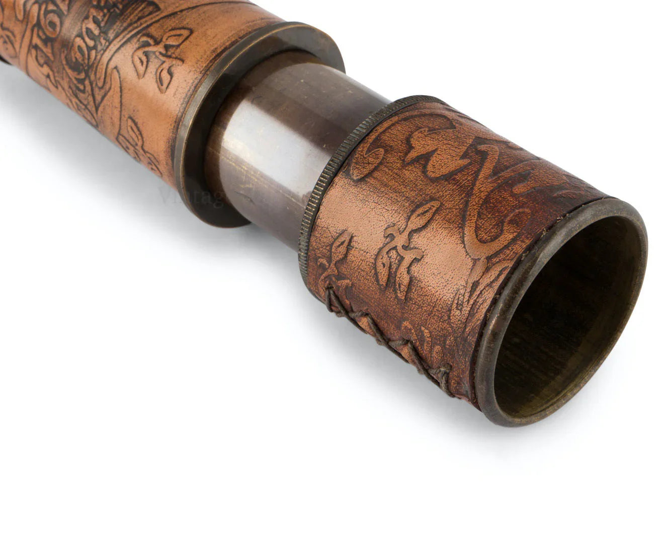 Vintage brass and leather telescope with engraved floral pattern close-up