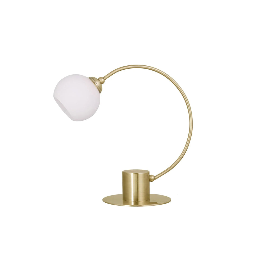 Modern brass table lamp with arched design and frosted glass globe shade on white background