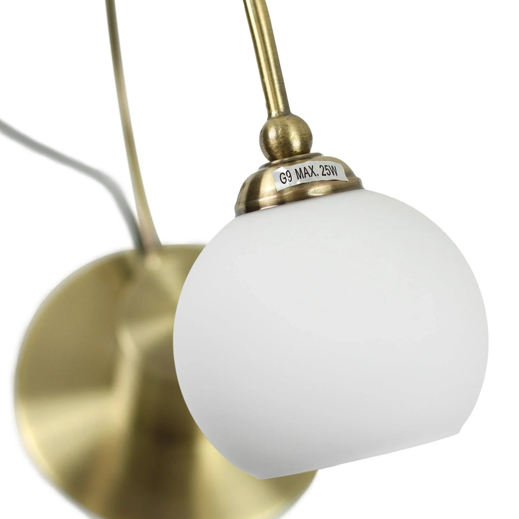 Brass wall sconce with frosted glass globe shade, G9 max 25W label visible