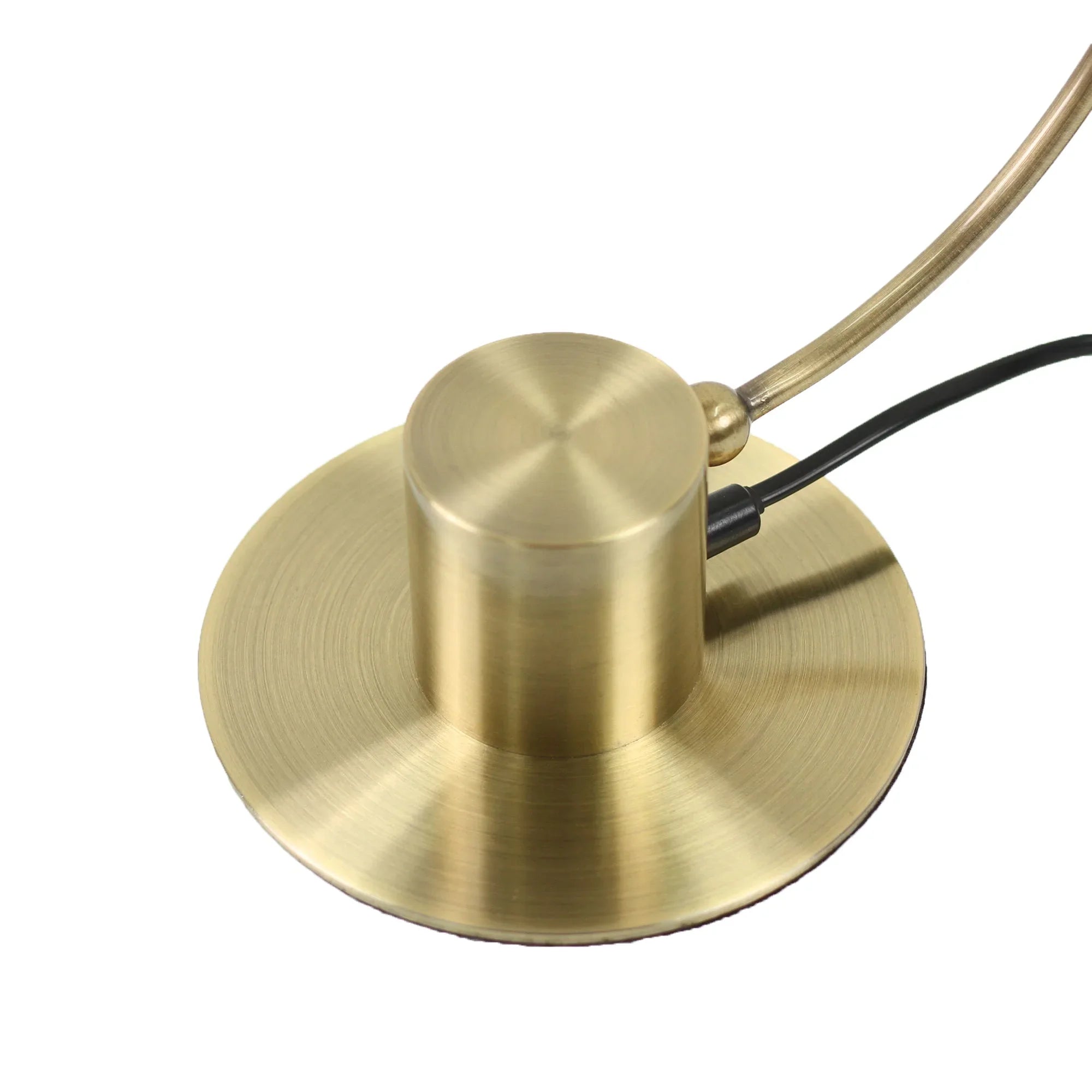 Brushed brass lamp base with curved arm and black power cord on white background