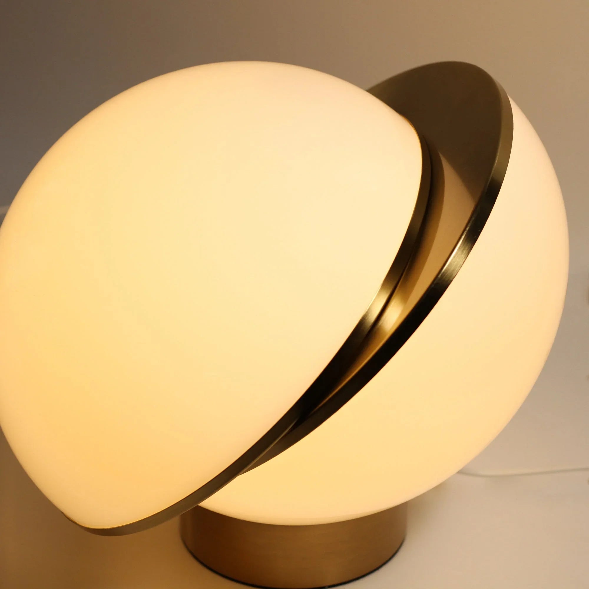 Modern globe table lamp with brass base and warm white frosted glass shade